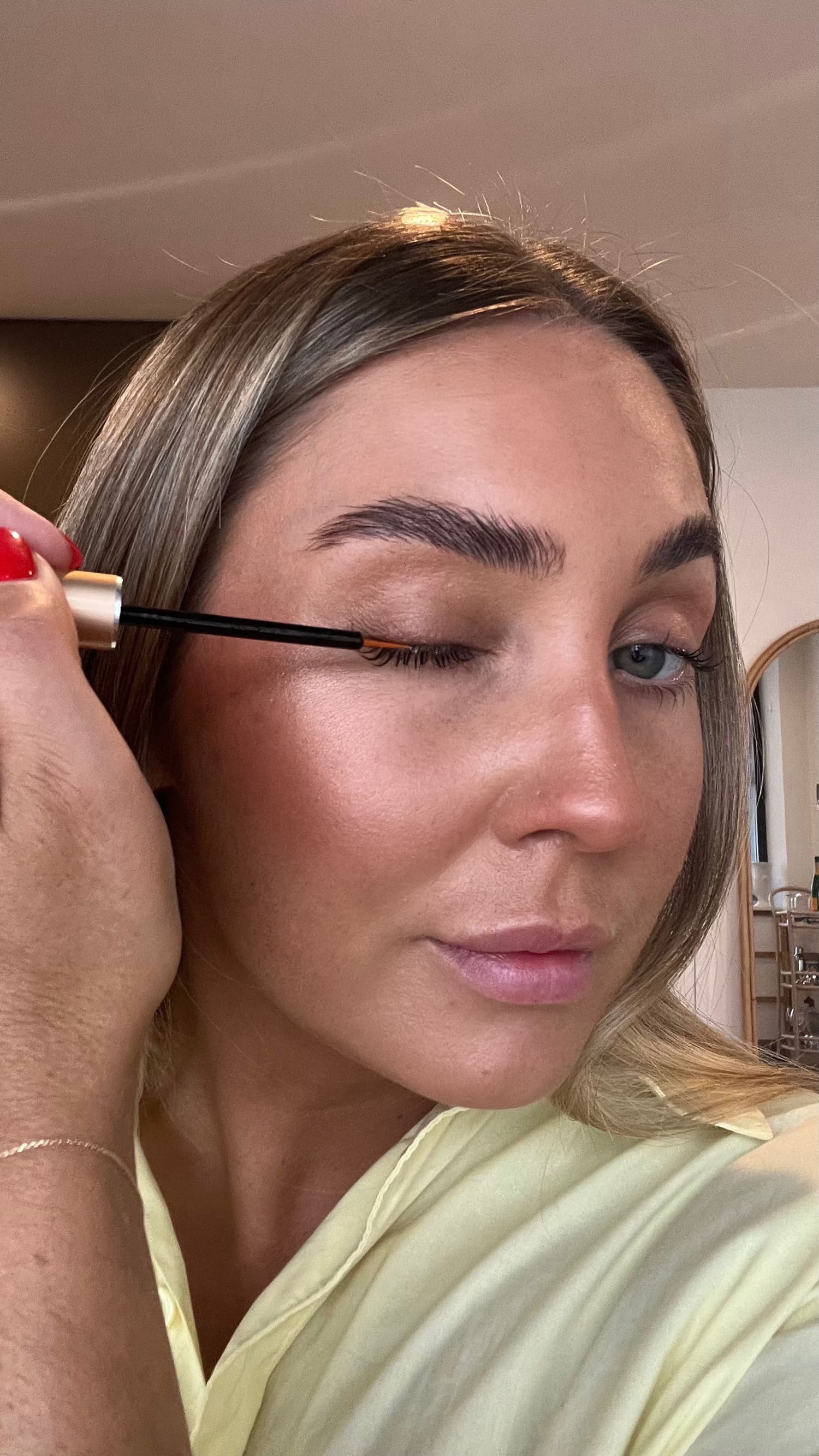 Woman applying growth serum to upper lashes