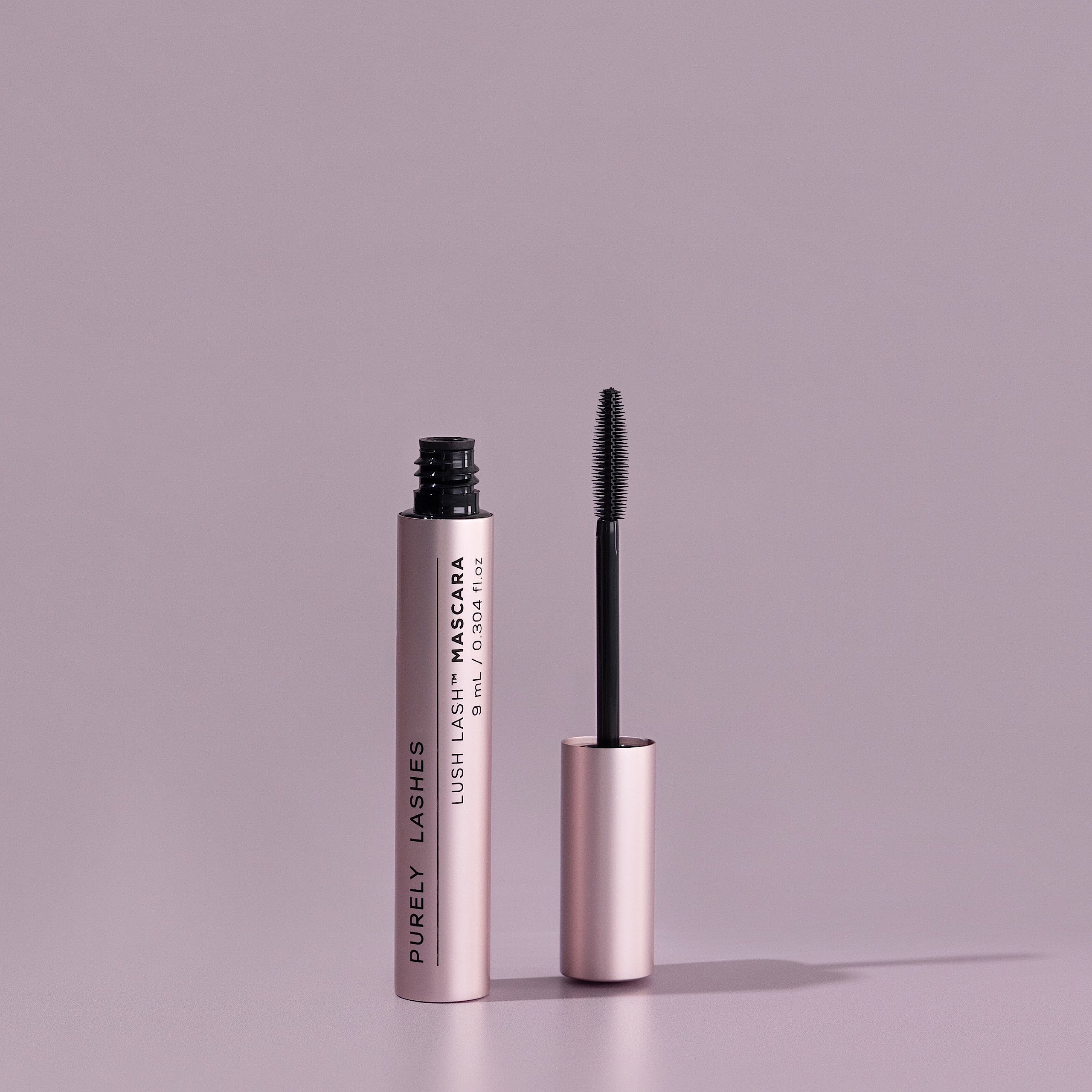 Lash Growth Mascara tube with the mascara brush applicator sitting beside out of the bottle
